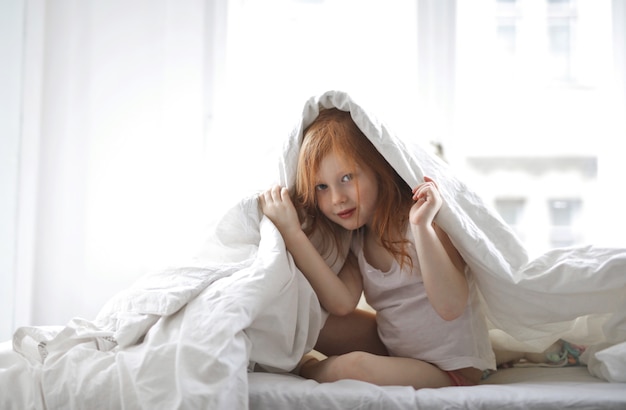 Klein meisje onder de deken
