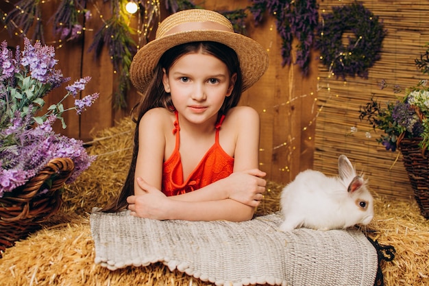 Klein meisje op de boerderij zit met een paasvakantieconcept van konijn