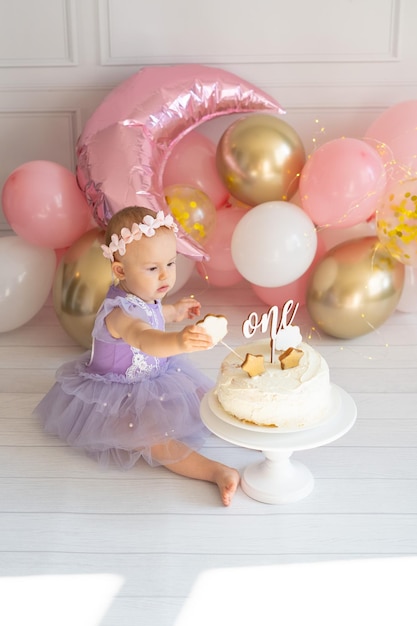 Foto klein meisje op de vloer en spelen met zijn taart op zijn eerste verjaardag smash cake