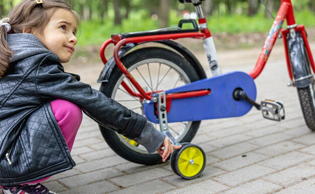 Klein meisje op een wandeling in het park met haar fiets.