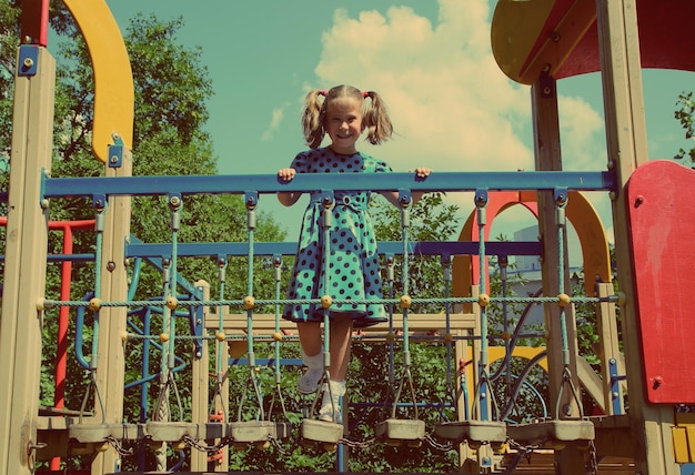 Klein meisje op speelplaats vintage retro stijl