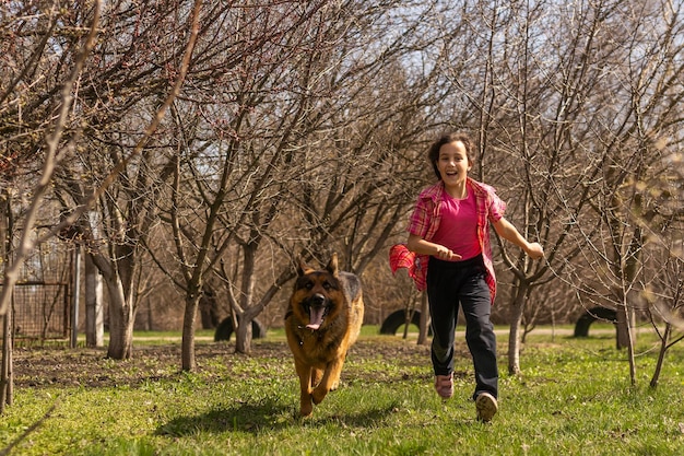 klein meisje rent snel met een herder in het park.