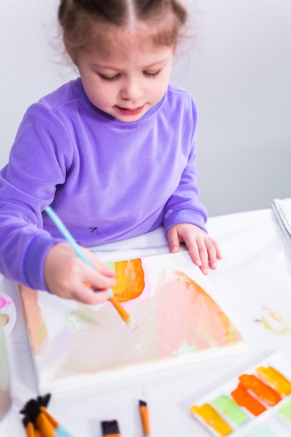 Klein meisje schilderen op canvas met arcylic verf.