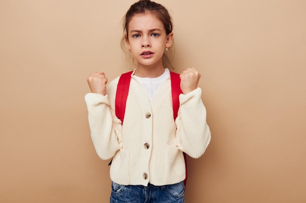 Foto klein meisje schoolmeisje met rode rugzak poseren jeugd ongewijzigd