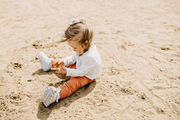 Klein meisje speelt in het zand op een strand