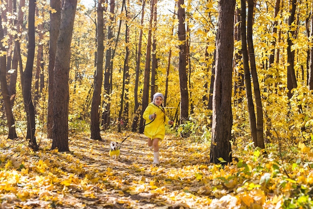 Klein meisje speelt met haar hond in het herfstbos