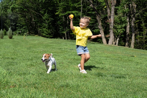 Klein meisje speelt met haar hond Jack Russell Terrier in het park