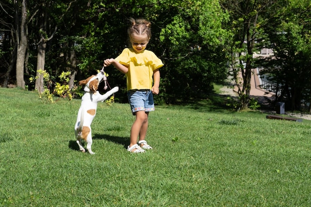 Klein meisje speelt met haar hond Jack Russell Terrier in het park