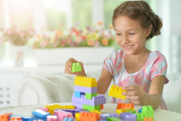 Klein meisje speelt met kleurrijke plastic blokken