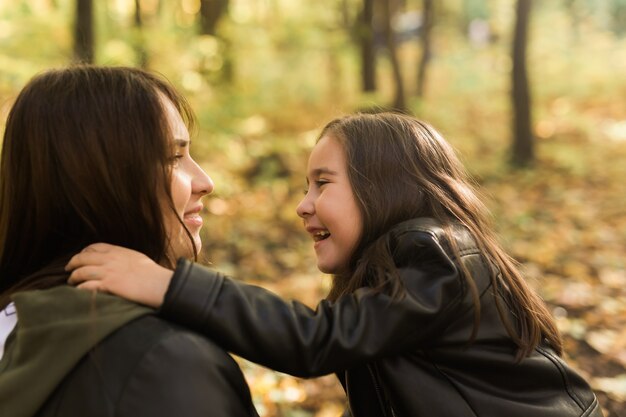 Klein meisje speelt met moeder in het herfstpark