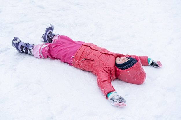 Klein meisje speelt met sneeuw. Winter vakantie