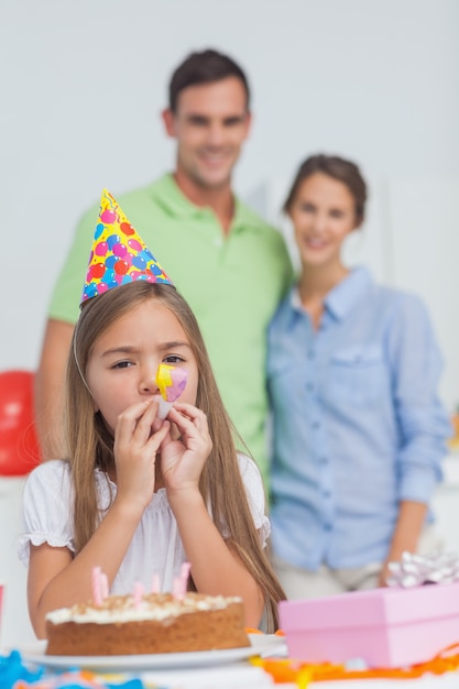 Klein meisje spelen met een feest hoorn