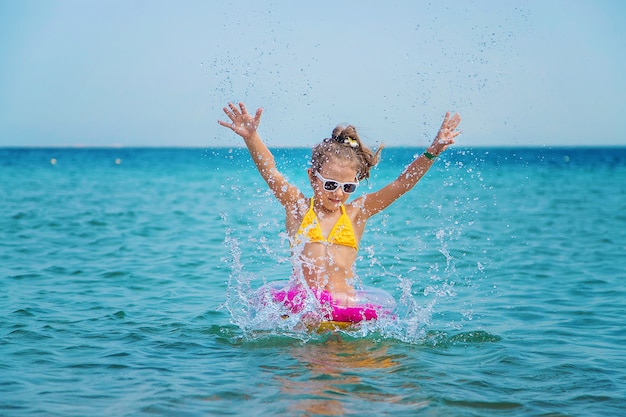 Klein meisje spettert water in de zee