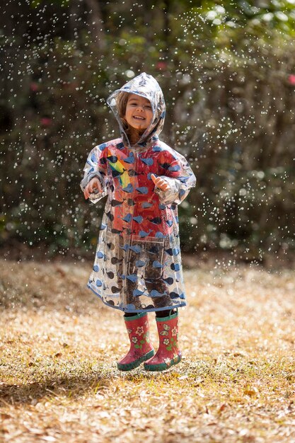 Klein meisje springen in de regen