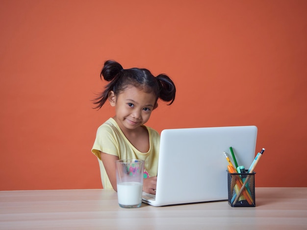 Klein meisje studeert met laptop