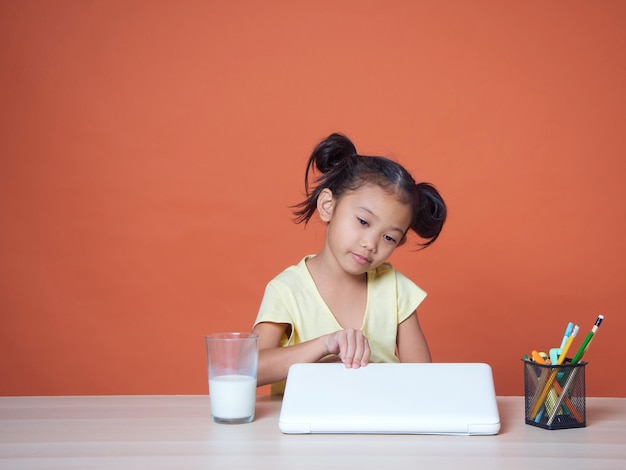 Klein meisje studeert met laptop