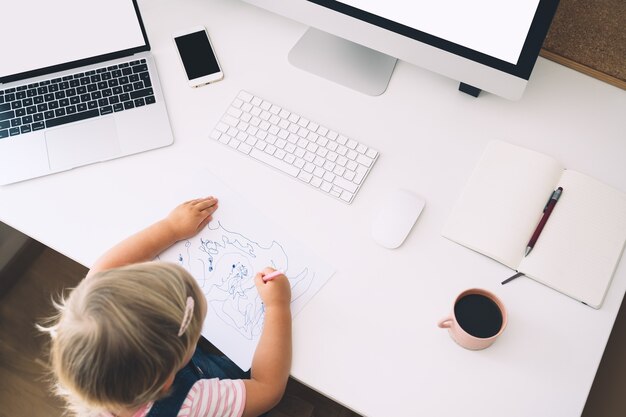 Klein meisje studeren en tekenen aan bureau kinderen online leren