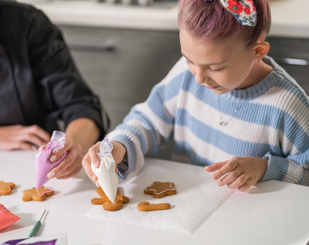 Klein meisje tekent een patroon op cookies cookie masterclass