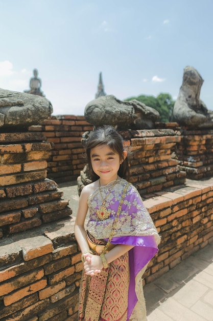 klein meisje Thaise traditionele jurk met oude ruïne