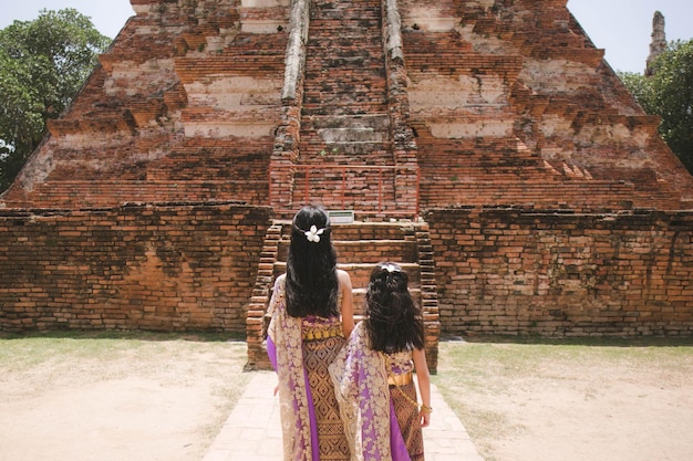 klein meisje Thaise traditionele jurk met oude ruïne