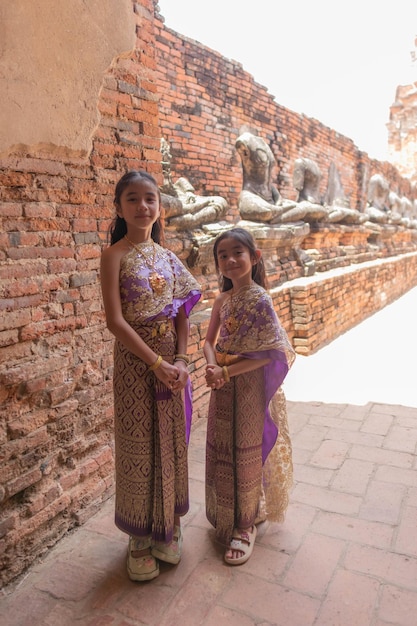 klein meisje Thaise traditionele jurk met oude ruïne