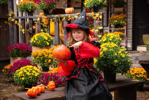 klein meisje verkleed als heks met een pompoen viert halloween