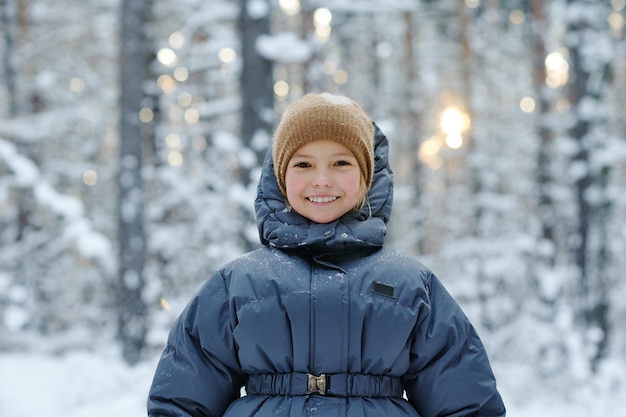 Klein meisje wandelen in het winterbos