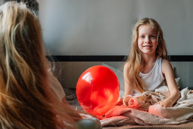 Klein meisje wenst haar vriendin een gelukkige verjaardag in de ochtend geeft een hartballon