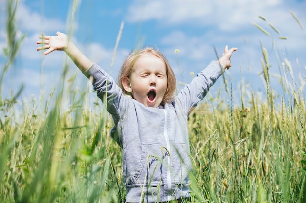 Klein mooi meisje buiten in een veld in de frisse lucht gelukkig