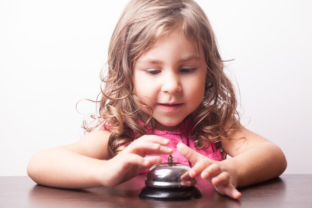 Klein mooi meisje druk op de bel, bordspel op tijd