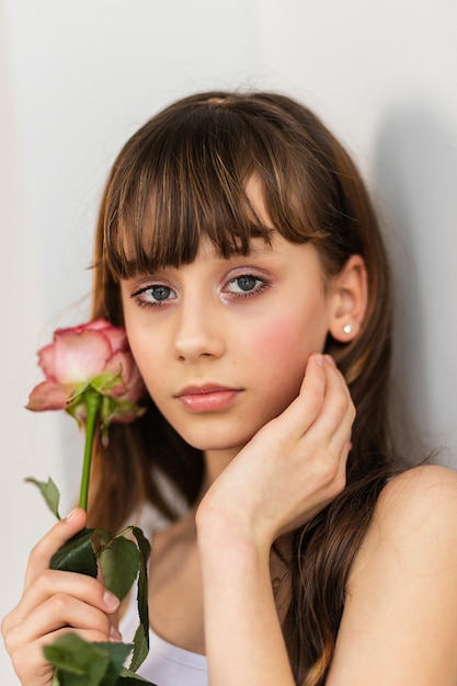 Klein mooi meisje in roze houdt het boeket rozen. Close-up van de bloemen en het gezicht, kleine ballerina met een boeket