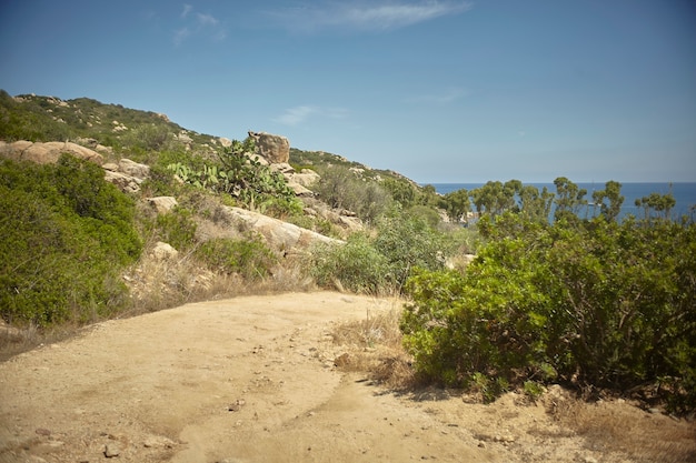 Klein onverhard bergpad: een pad dat naar de zee leidt op de meest afgelegen stranden van de zuidkust van sardinië in italië.