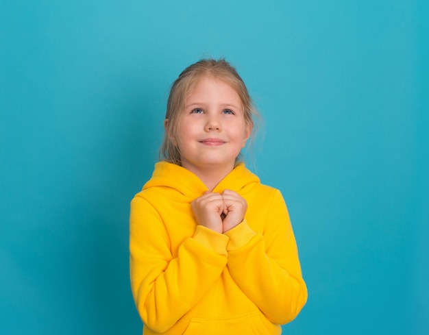 Klein oprecht meisje in gele hoodie hand in hand op borst gevoel dankbaarheid adoptie concept