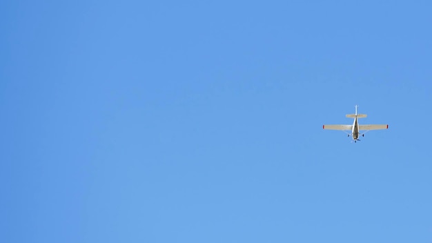 Klein recreatief vliegtuig, ideaal voor vliegoefeningen die op een heldere dag over een blauwe lucht vliegen
