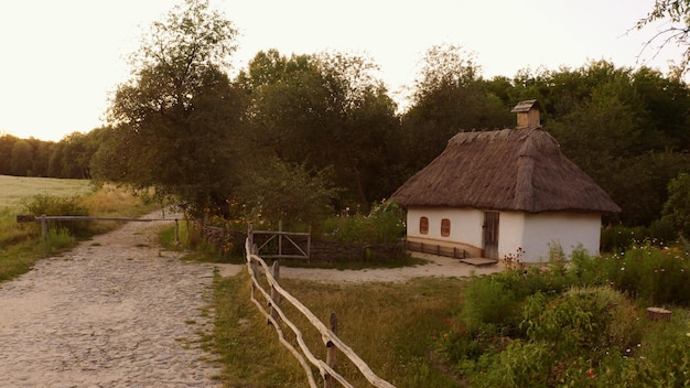 Klein schattig huis omgeven door een eenvoudig houten hek in landelijk gebied