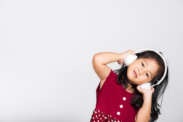 Klein schattig meisje 34 jaar oud luistert naar muziek in draadloze hoofdtelefoons