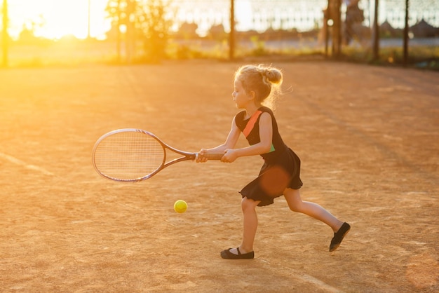 Klein schattig meisje aan het tennissen