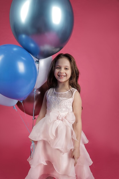 Foto klein schattig meisje glimlachend met grote ballonnen