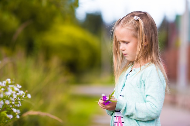 Klein schattig meisje in zomer park buitenshuis