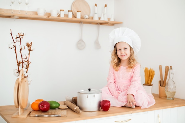 Klein schattig meisje koken in de keuken