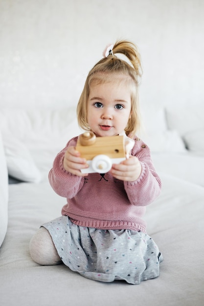 Klein schattig meisje met houten speelgoedcamera