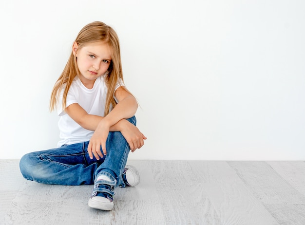 Klein schattig meisje op de vloer, glimlachend