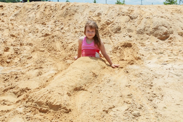 Klein schattig meisje op het strand mooi klein meisje in het zand op het strand