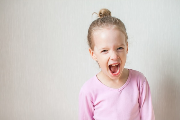 Klein schattig meisje toont emoties. Schreeuw, woede, woede, wild