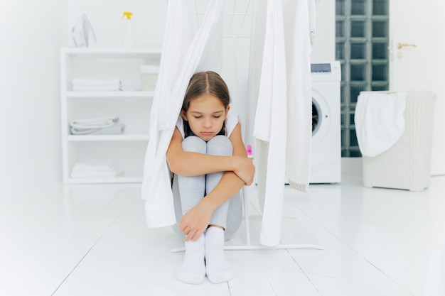 Klein schattig meisje zit op de vloer