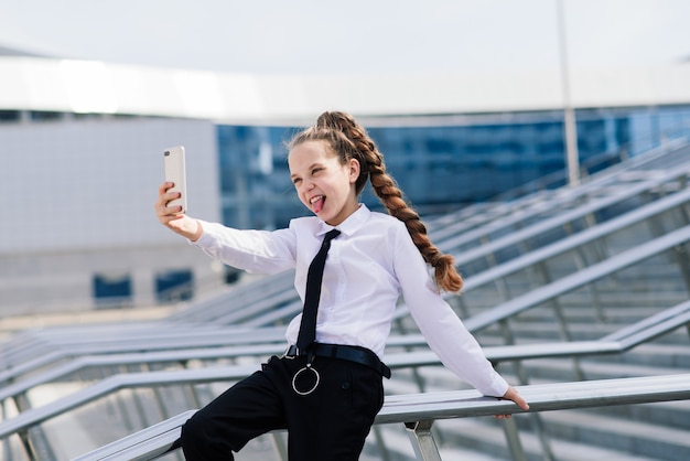 Klein schoolmeisje dat telefoongesprek met vriend heeft. moderne levenscommunicatie. Leven in een digitaal tijdperk.