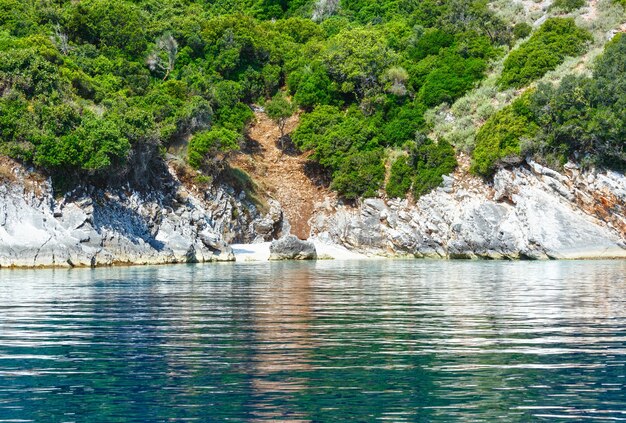 Klein strand en uitzicht op de zomerkust vanaf motorboot kefalonia, niet ver van agia effimia, griekenland