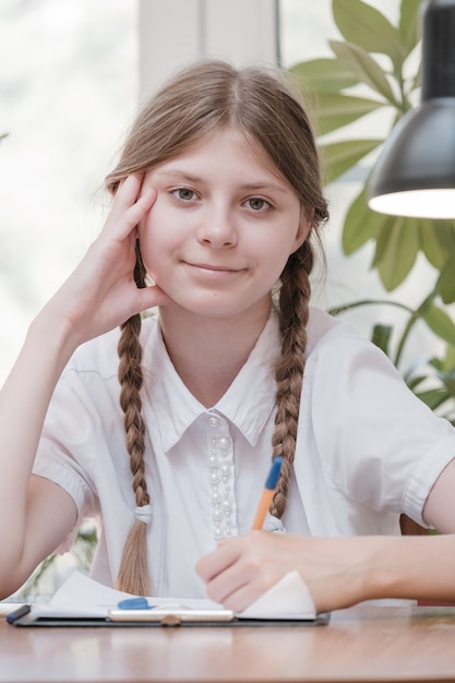 Klein studentenmeisje dat op school studeert. huishobby. glimlachend kindmeisje dat thuis schildert. laat je onderwijzen door de leraar versus leer en studeer thuis met de ouders. jong meisje huiswerk.