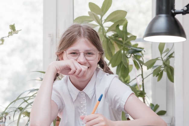 Klein studentenmeisje dat op school studeert. huishobby. glimlachend kindmeisje dat thuis schildert. laat je onderwijzen door de leraar versus leer en studeer thuis met de ouders. jong meisje huiswerk.