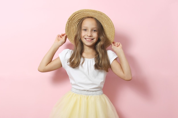 Klein vrolijk lachend meisje in modieuze kleding op een gekleurde achtergrond